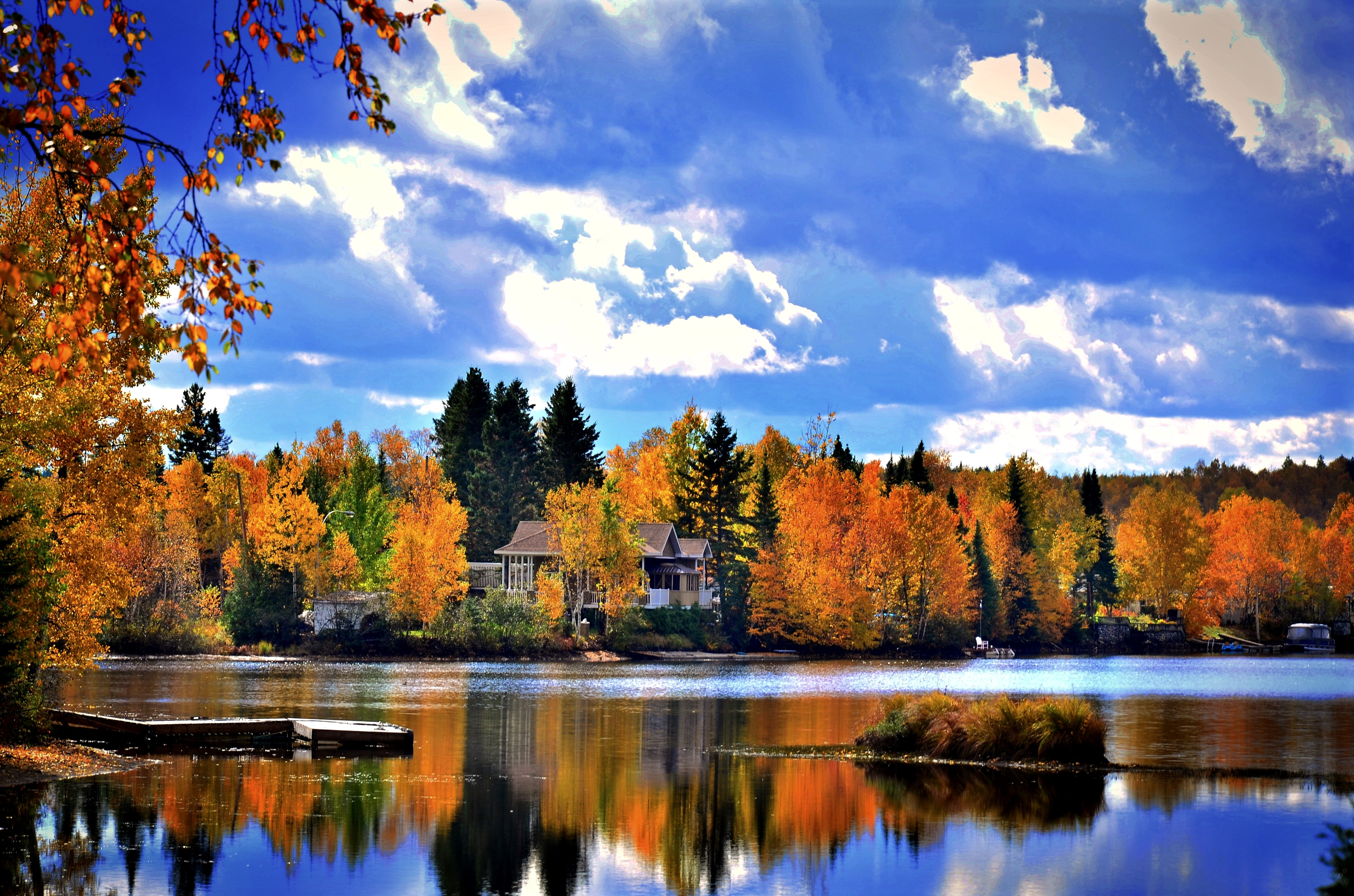 Haus an See mit herbstlichen Bäumen