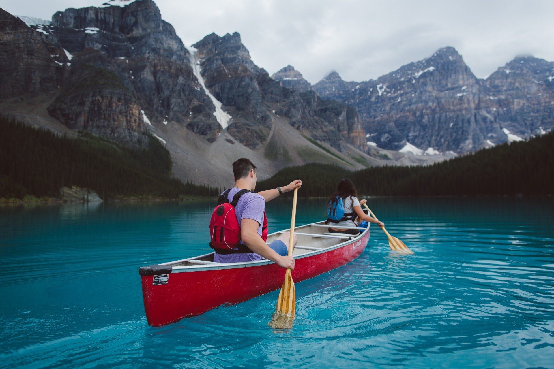 Paar in Kanu paddelt über den Moraine Lake in Kanada